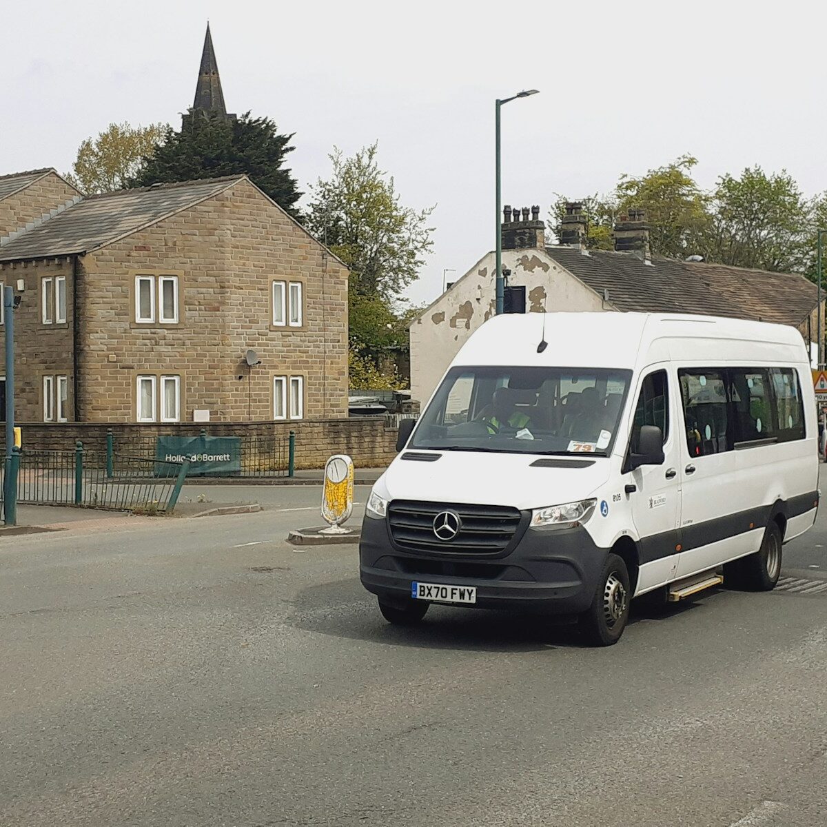 a white van driving down a street next to tall buildings